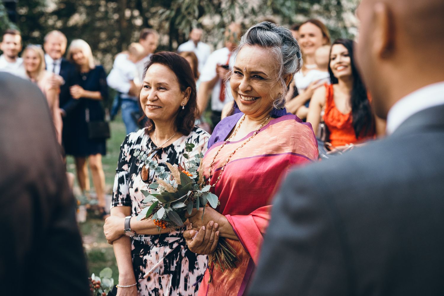Wedding celebration with guests enjoying festivities in an outdoor garden setting.