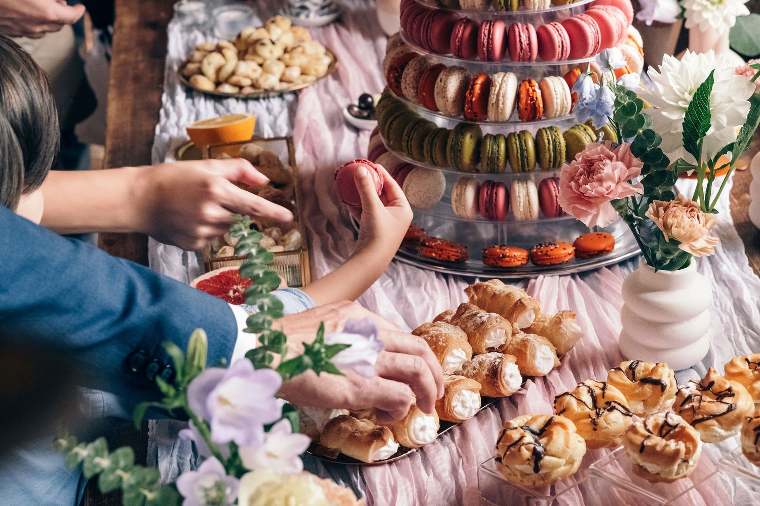 An elegant dessert table display featuring colorful macarons, pastries and sweets arranged for a special event.