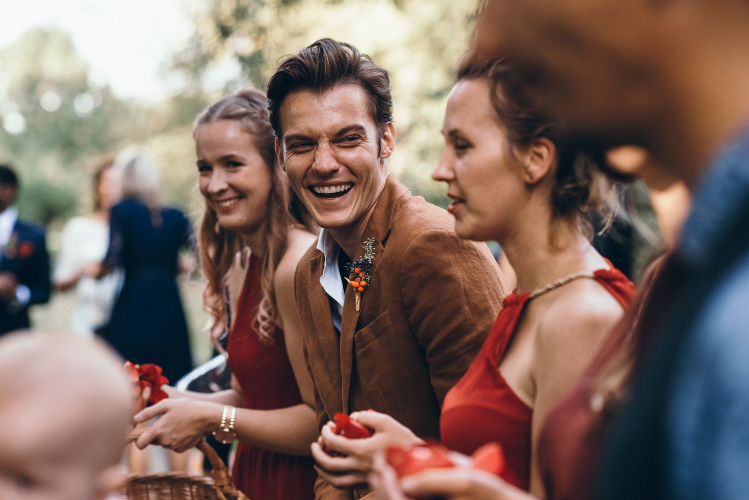 Wedding guests laughing and celebrating during an outdoor reception.