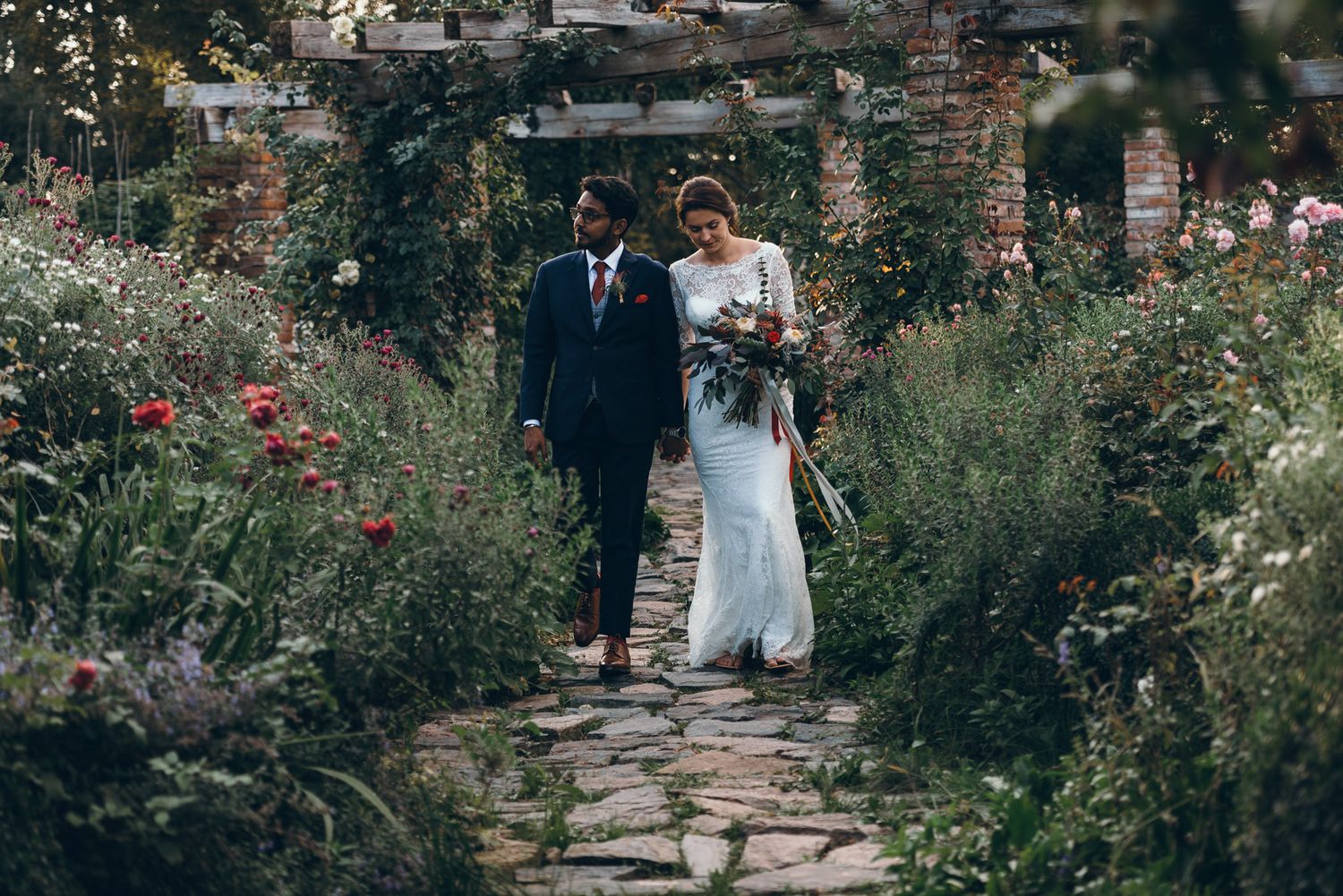 Stone pathway leads through a lush garden setting at an outdoor wedding venue.
