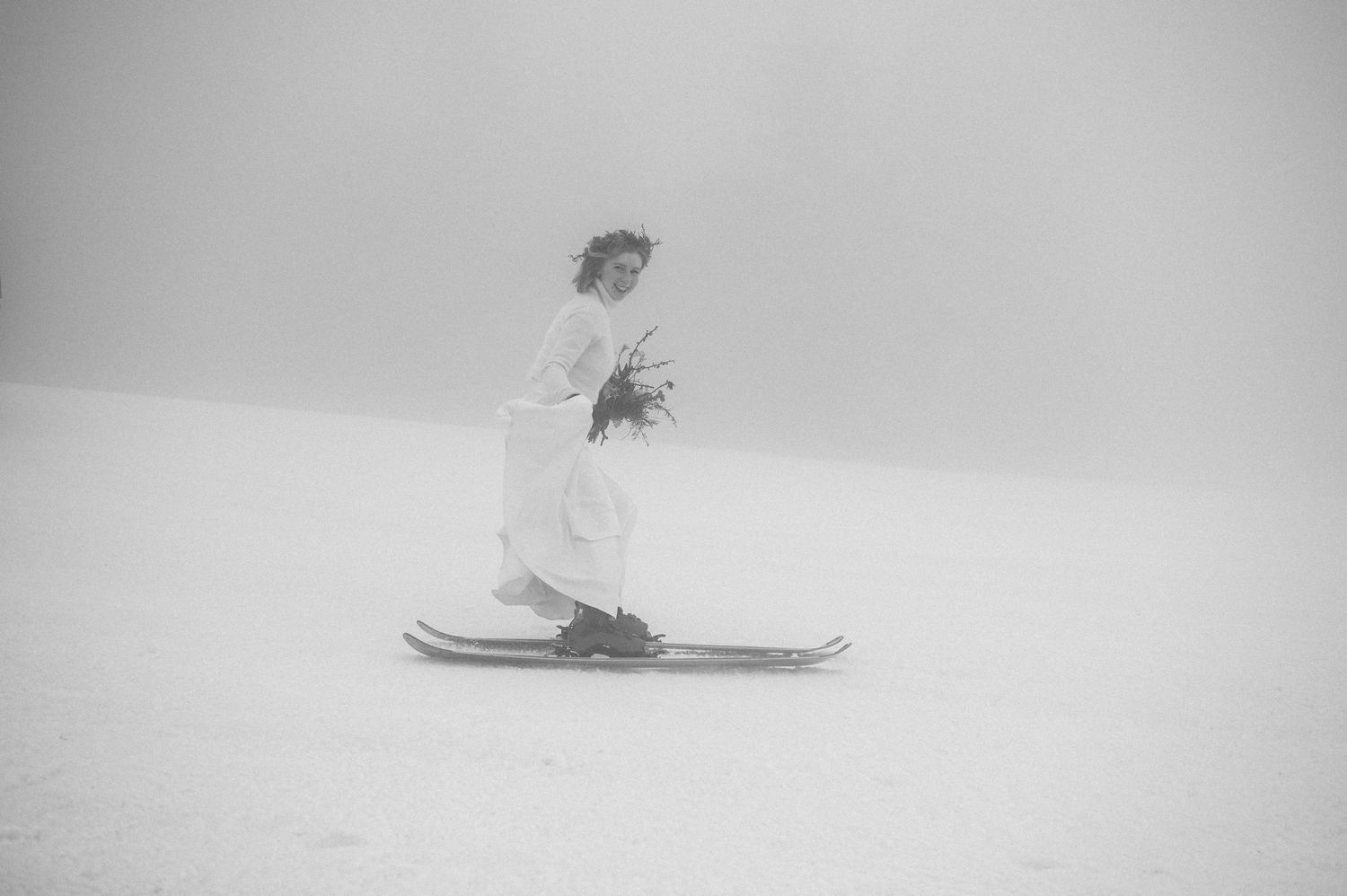 Black and white photograph of a skier in motion through foggy conditions.