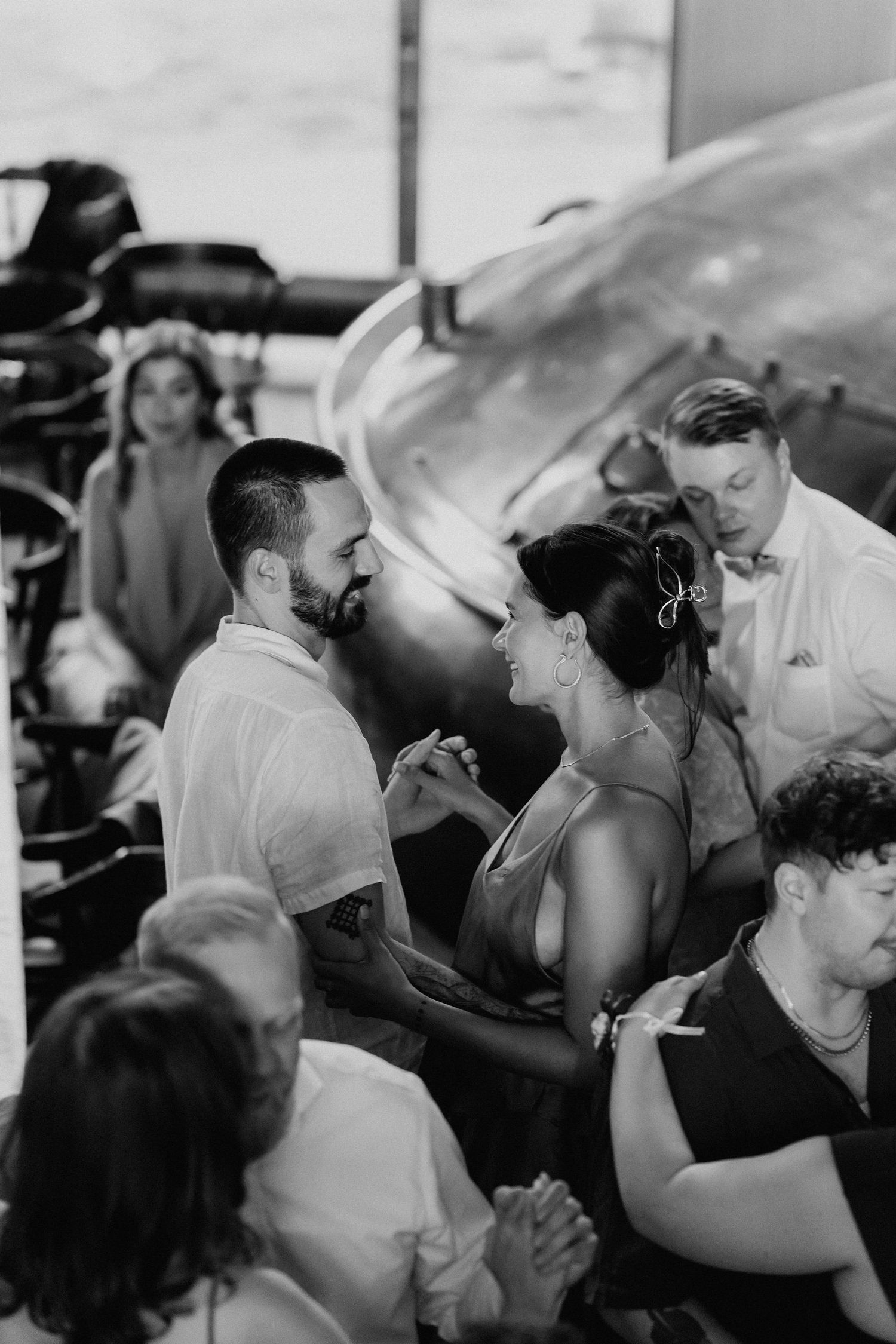 Black and white photo of couple sharing a joyful moment together at a wedding reception.