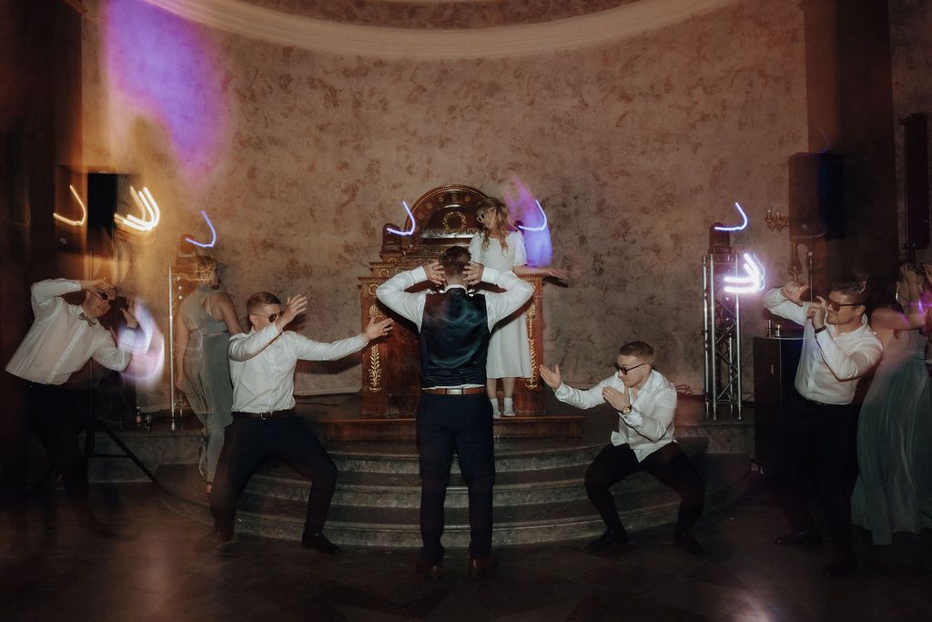 Groomsmen in white shirts perform dramatic choreographed wedding dance with light painting effects.