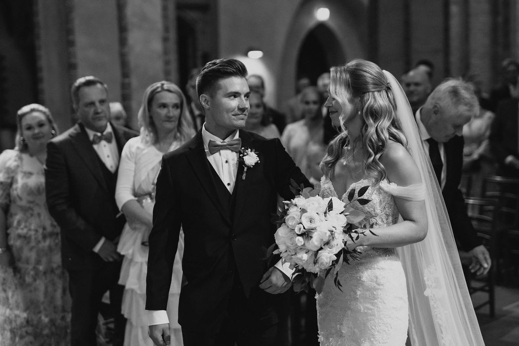 Bride and groom share emotional first look moment at church wedding ceremony altar.