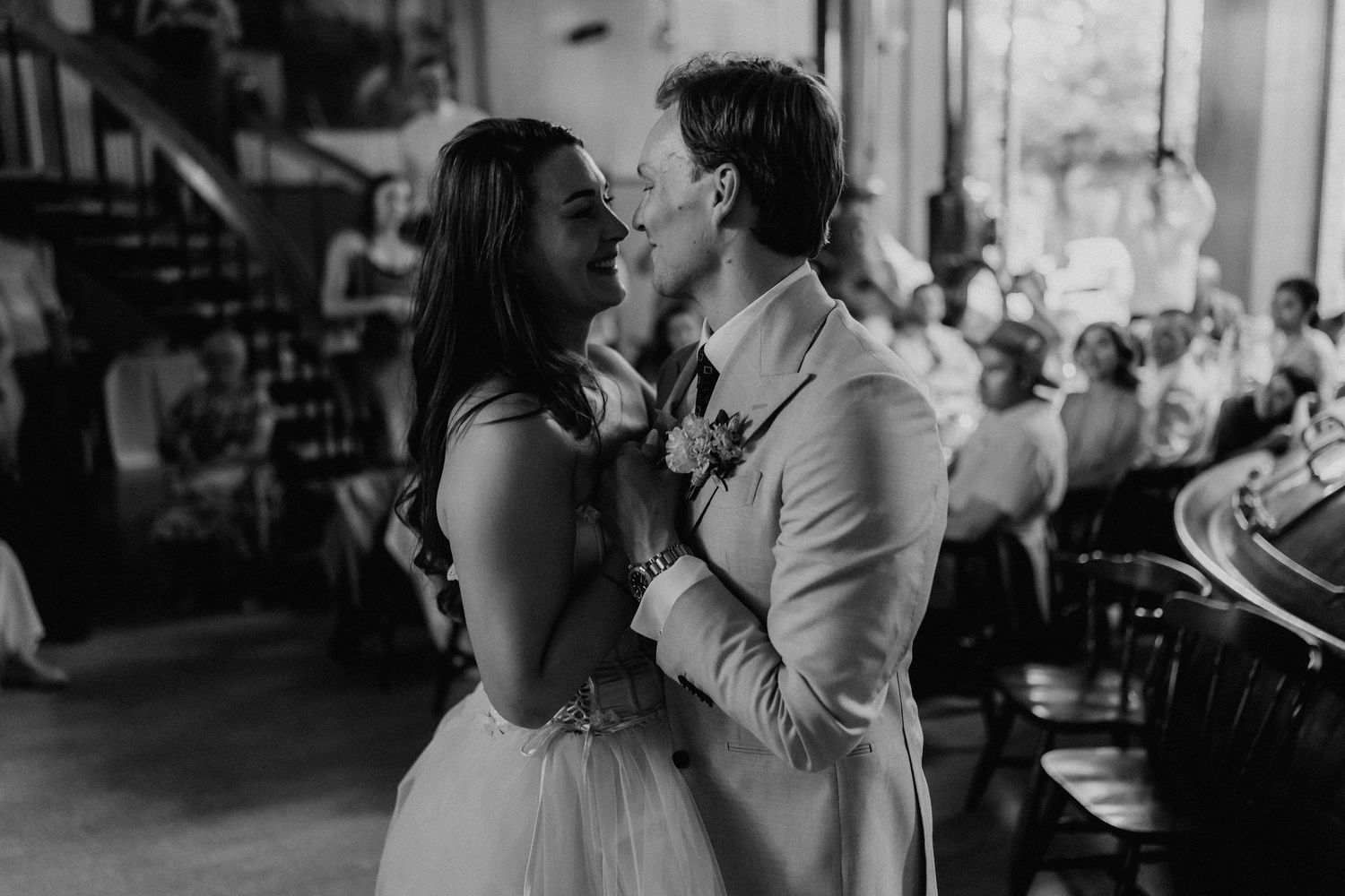 Black and white photo of bride and groom sharing a tender first dance at their wedding reception.