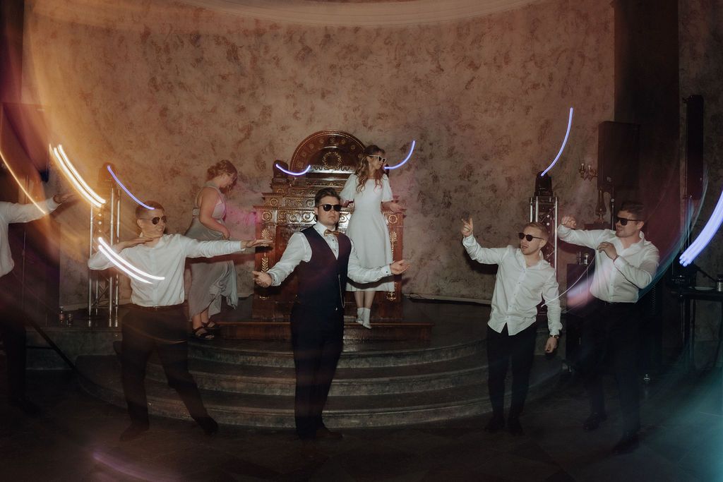 Wedding party performs stunning choreographed dance with light painting trails at elegant reception venue.