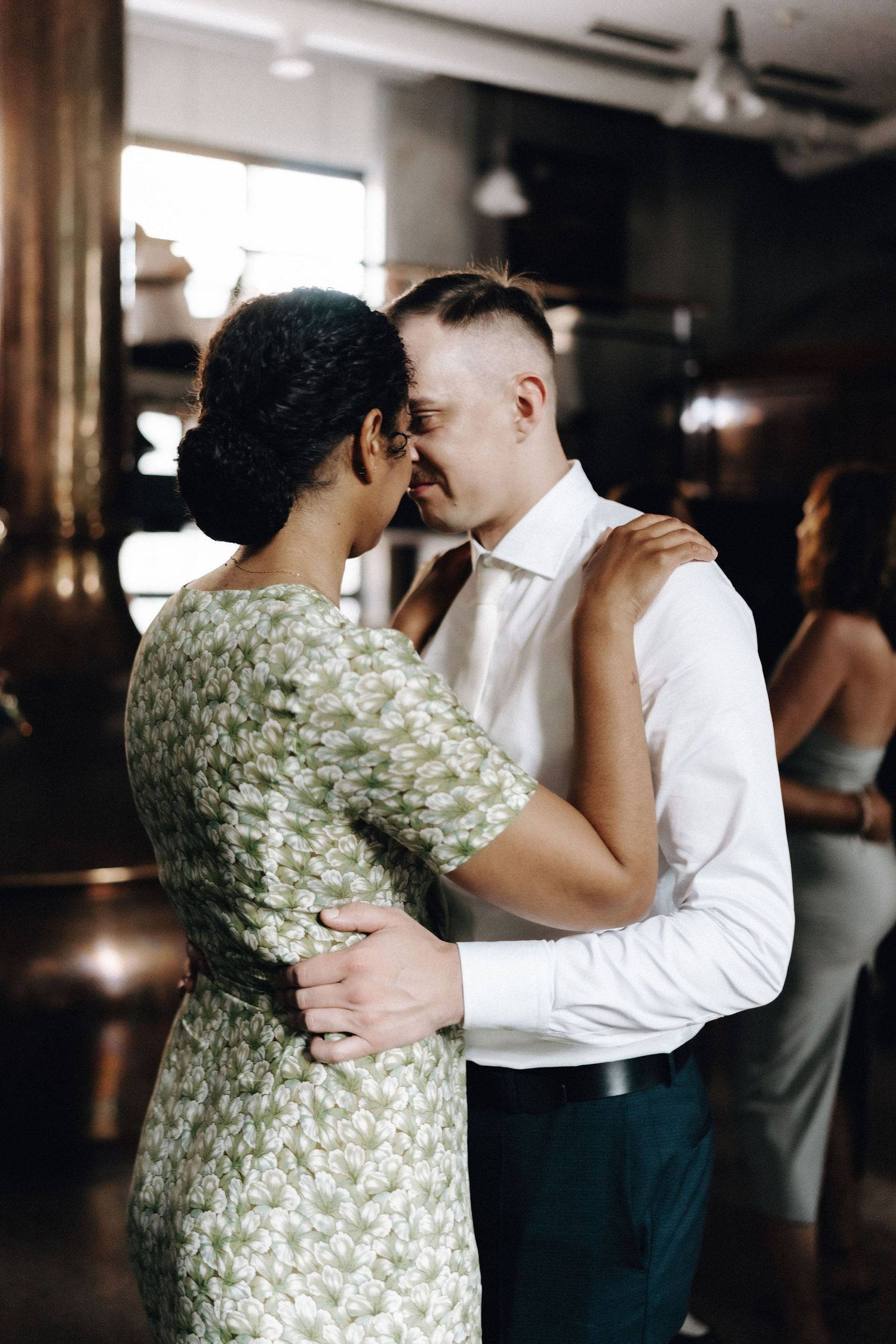 Couple shares intimate dance moment at a wedding reception in an industrial venue.