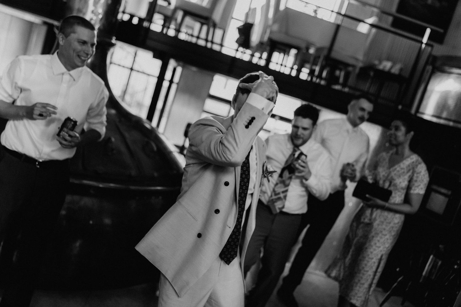 Guest performs entertaining dance moves at wedding reception in black and white photo.