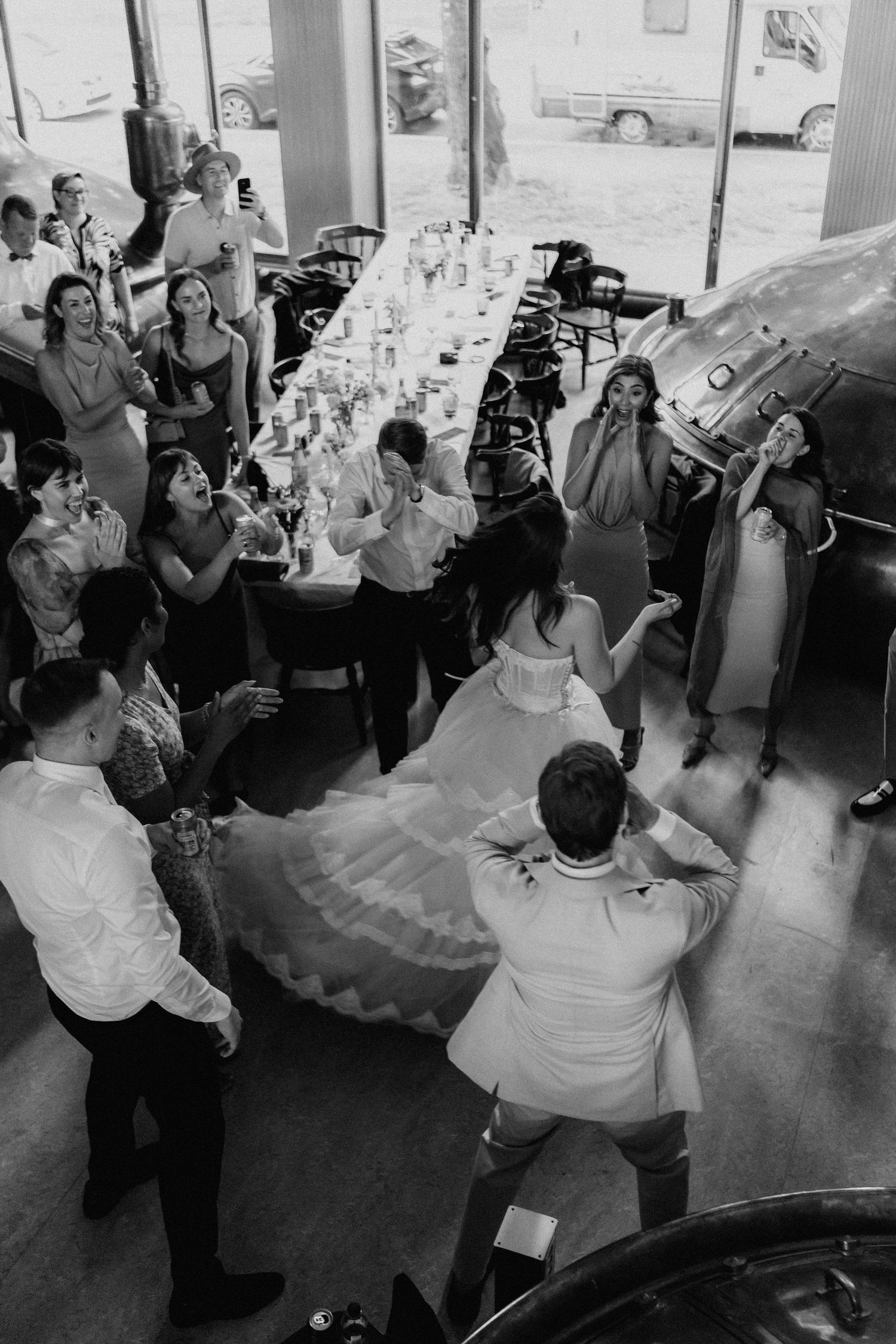 Black and white aerial view of bride and groom dancing at wedding reception.
