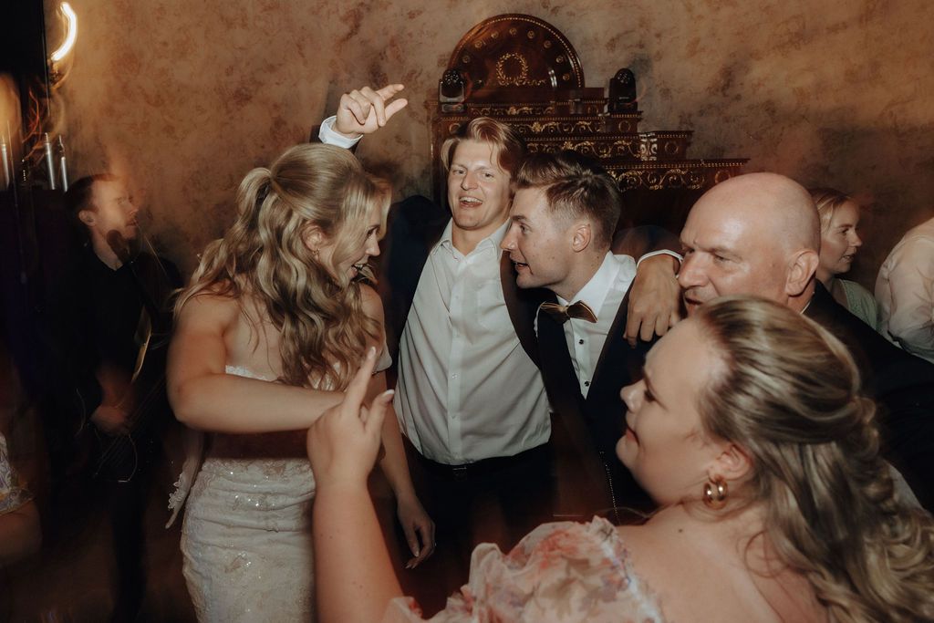 Bride and groom sharing a joyful dance moment with wedding guests at their reception.