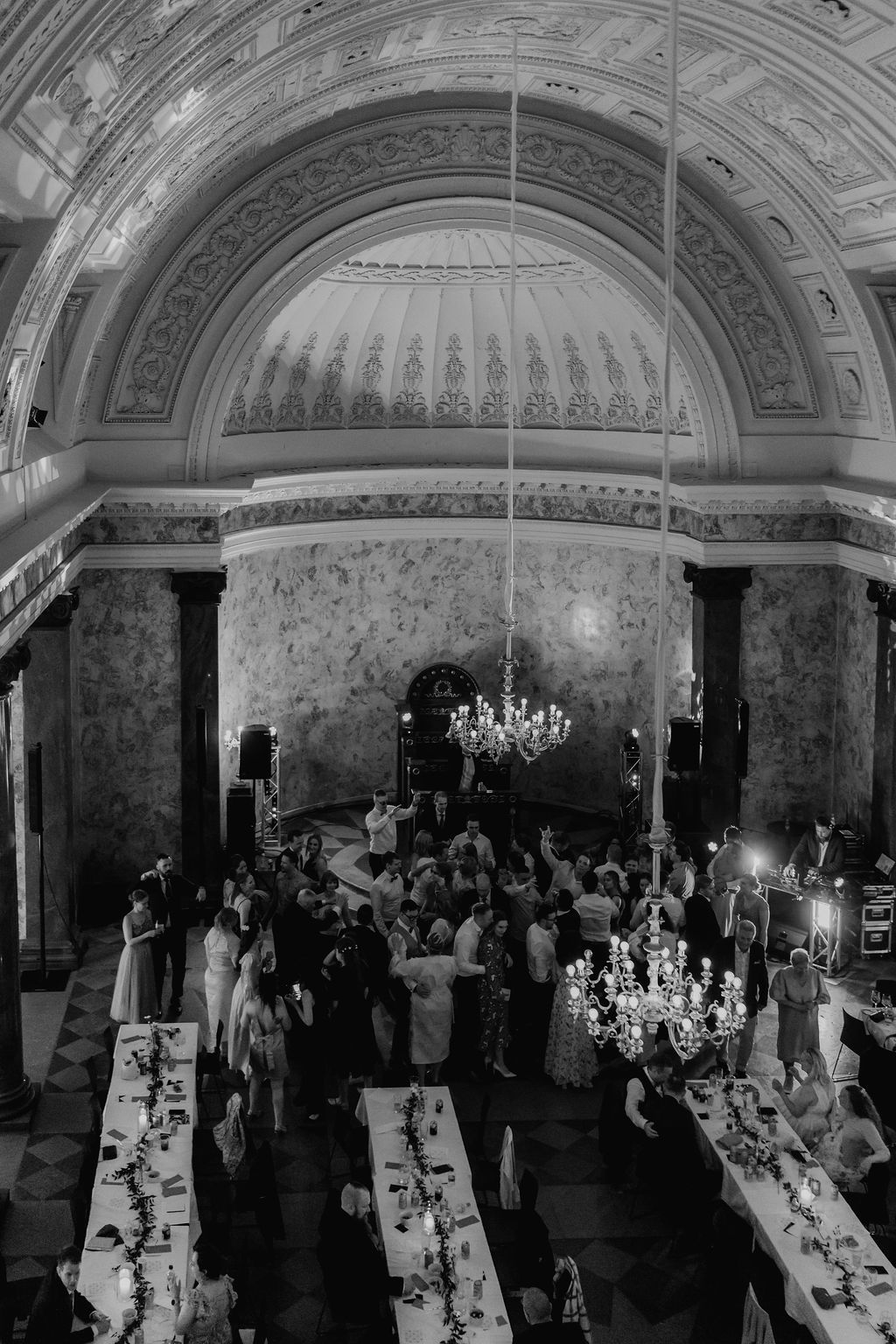 Black and white aerial view of wedding reception in stunning historic hall with arched ceiling.
