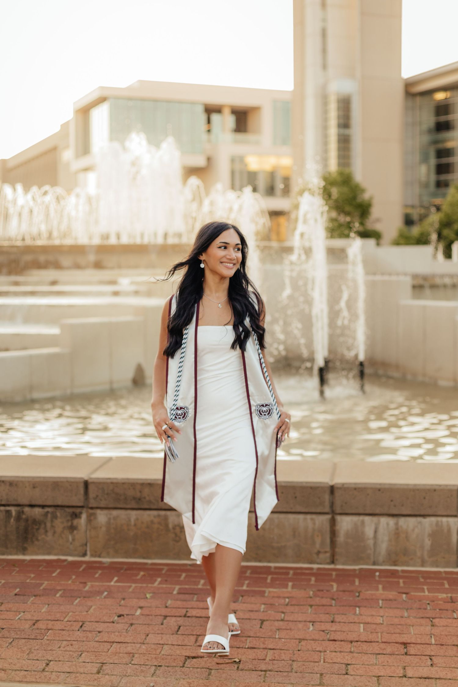 graduate walking wearing MSU stole and white dress