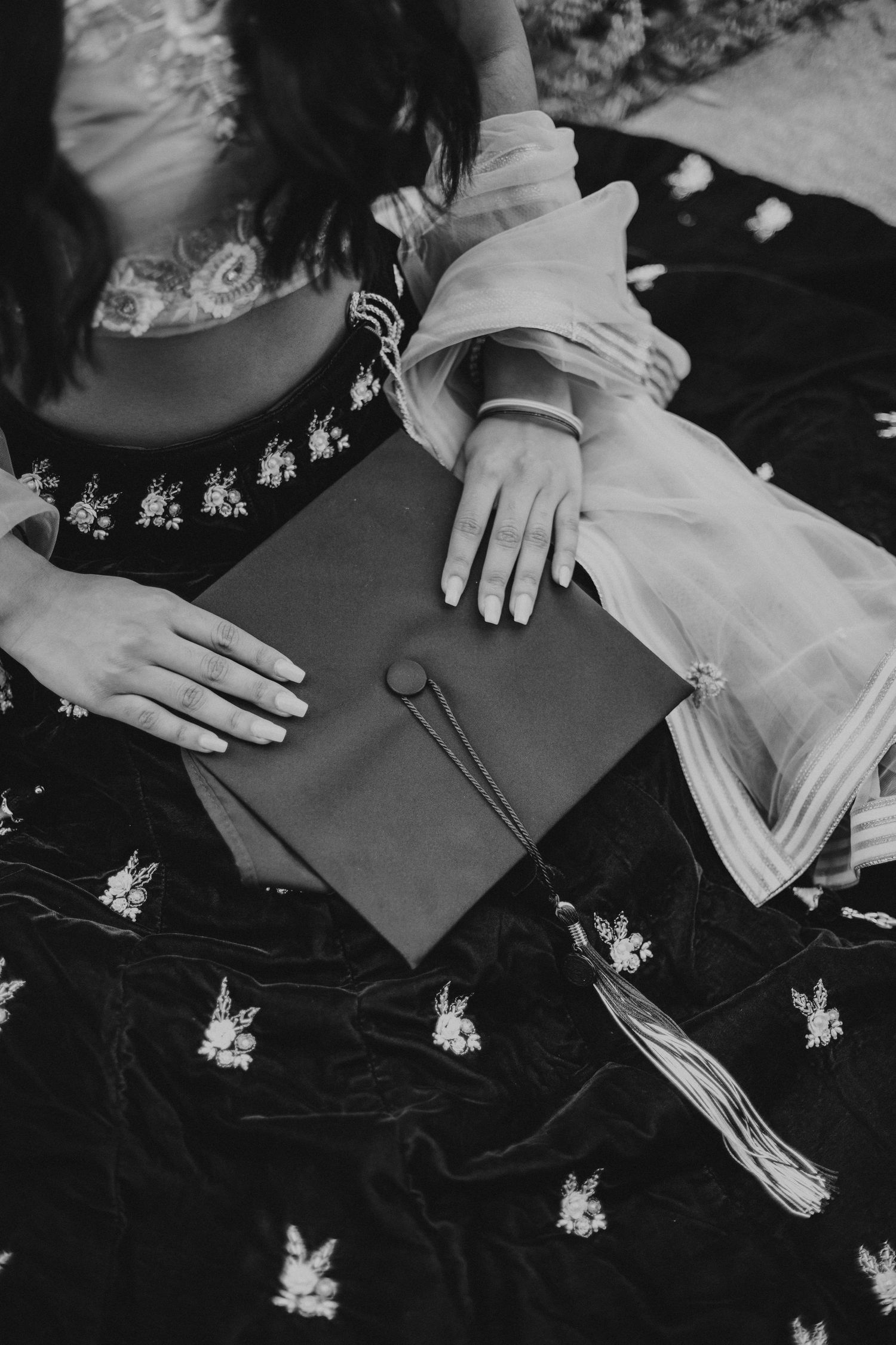 graduation cap sitting in lap of woman wearing lehenga skirt