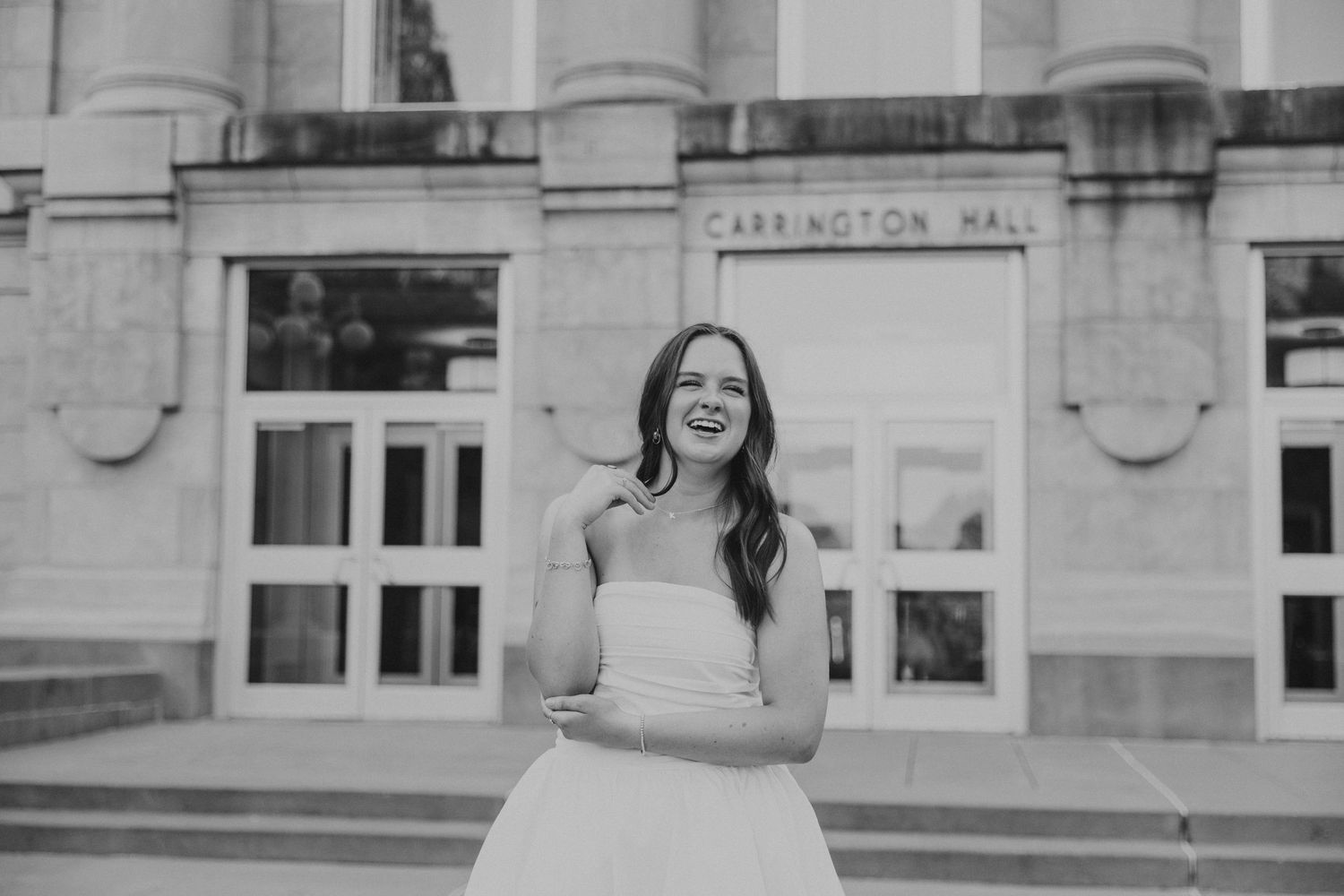 missouri state grad in front of carrington hall with arm crossed in front of her