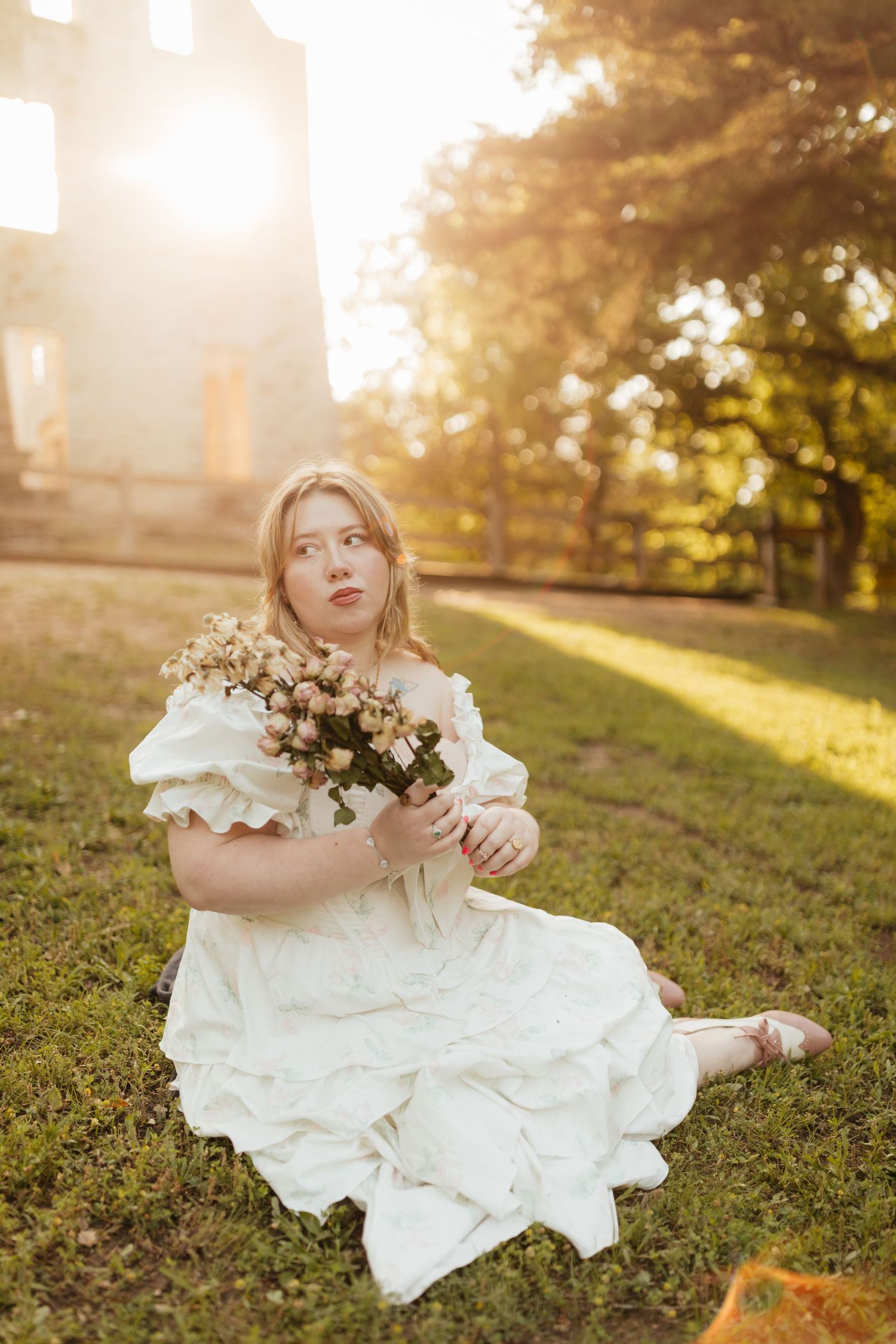 woman sitting in front of castle ruins at Ha Ha Tonka with frilly dress and dried flowers