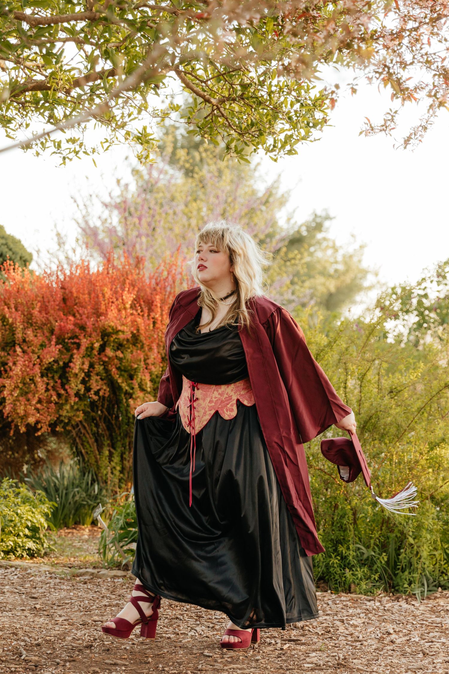 grad in a corset and black dress walking in garden