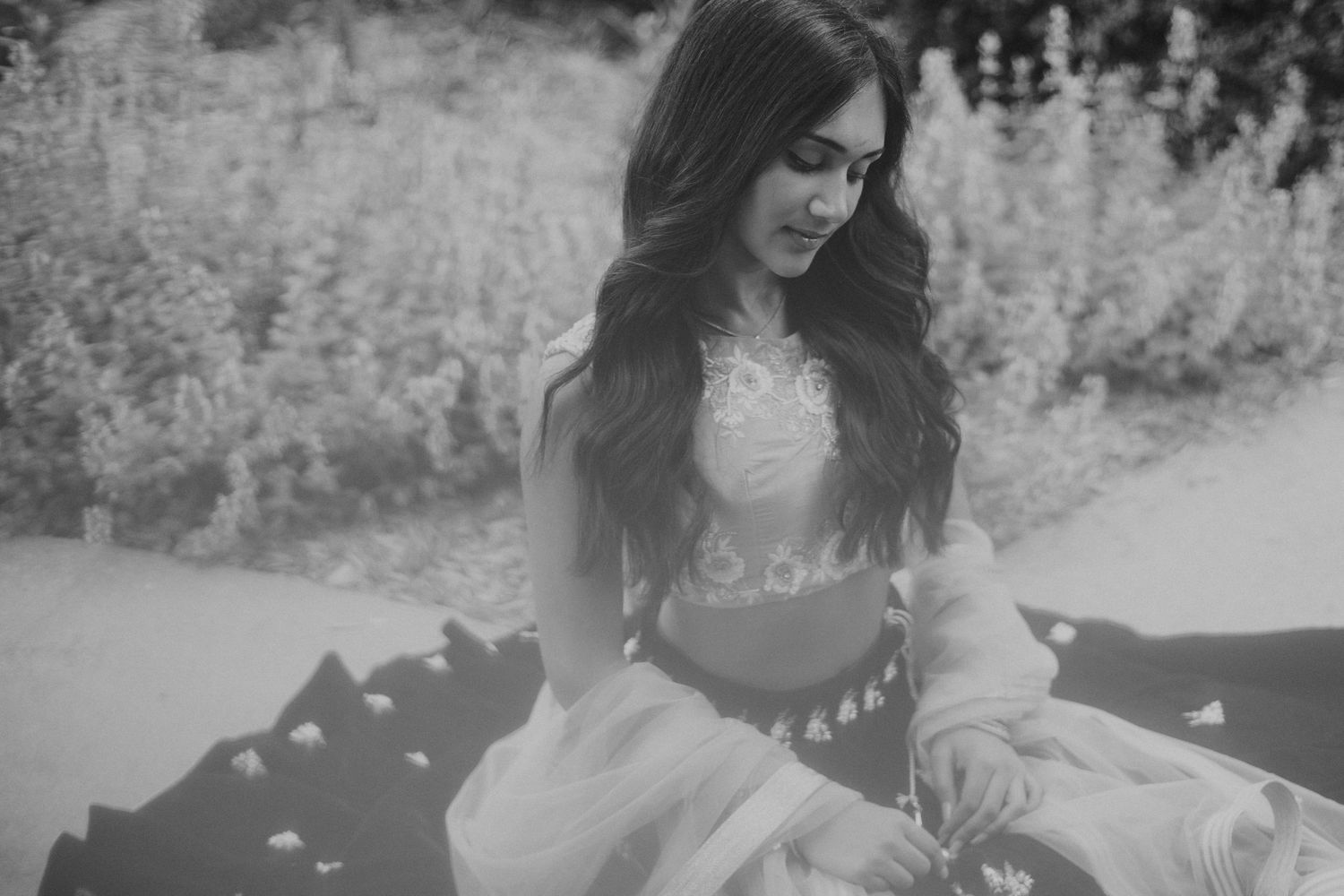 woman in traditional lehenga sitting and looking down at her lap