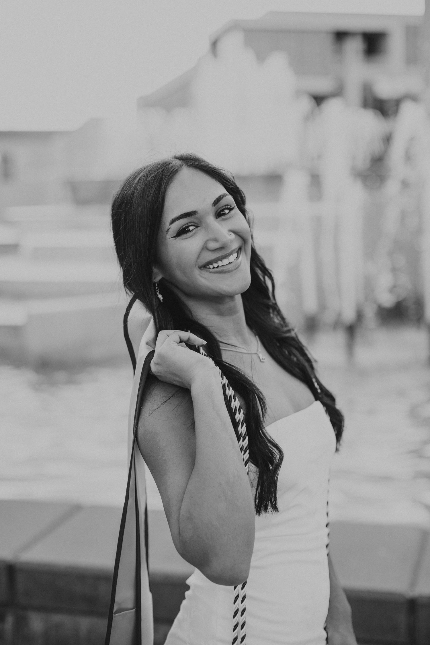 MSU grad holding stole on her shoulder in front of fountain