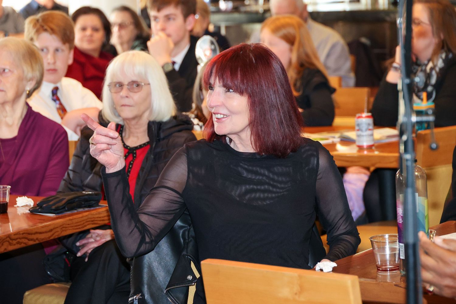 People seated at tables enjoying a social gathering in an indoor venue.