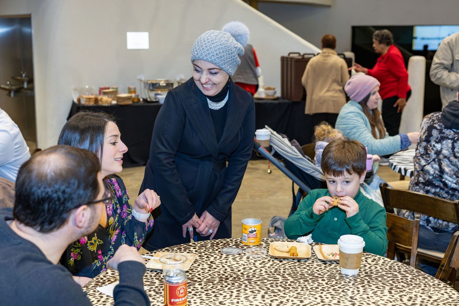 Guests socializing around tables at a festive indoor event.