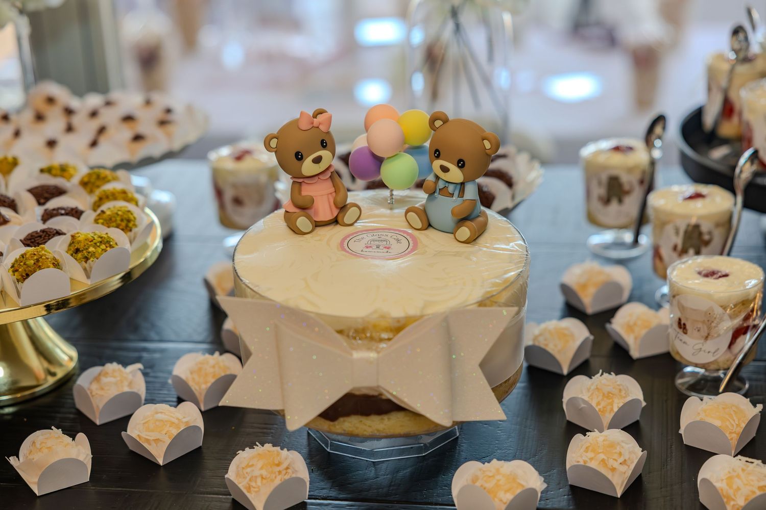 Elegant wedding cake display with white frosted cupcakes arranged on tiered stands at a reception.