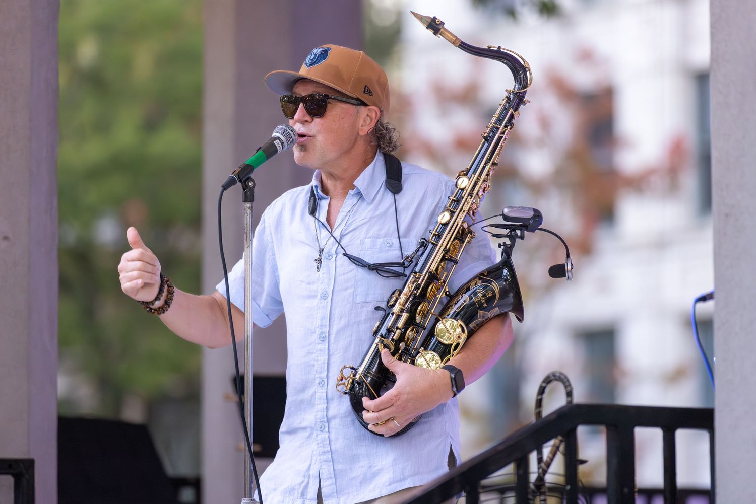 Musicians performing with instruments at an outdoor venue.