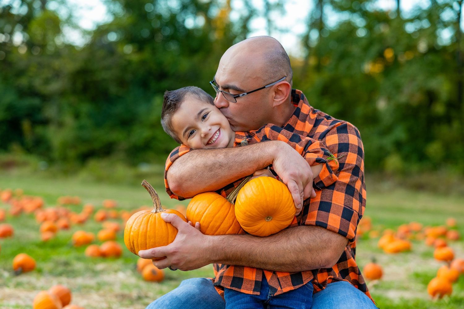 Autumn pumpkin patch scene with orange pumpkins scattered across a green field.