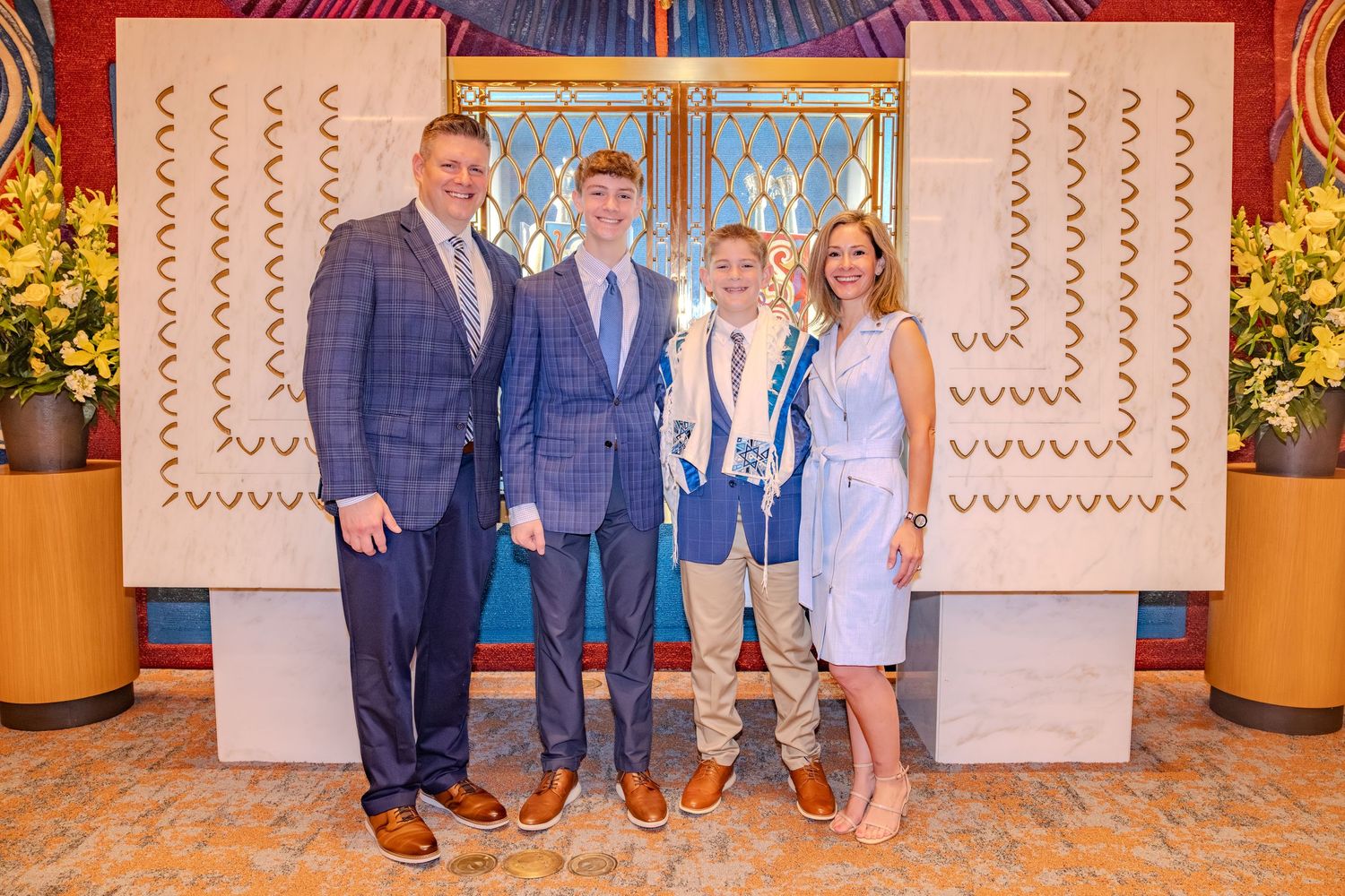 Family of four posing together at an elegant venue, dressed in formal attire for a special celebration.