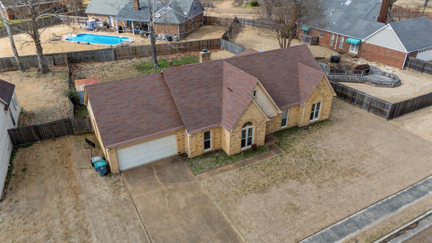 Aerial panoramic view of residential neighborhood with ranch-style homes and scattered trees in suburban area.