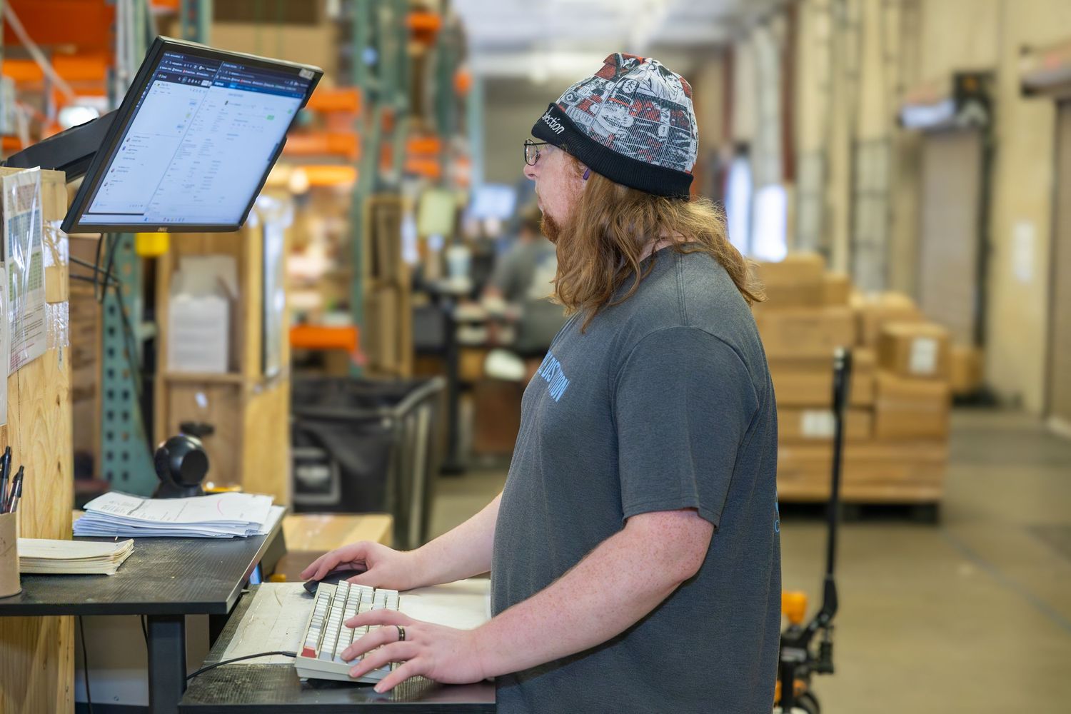 Warehouse worker scanning items while wearing headset for inventory management.