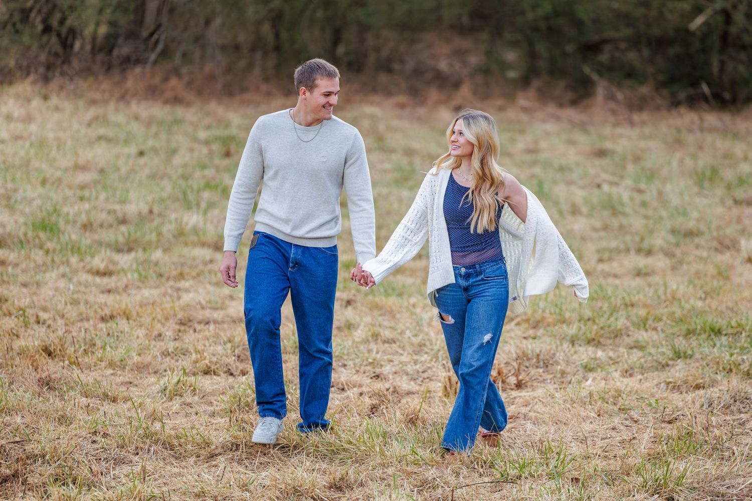 Two people strolling through a natural outdoor setting wearing coordinated casual outfits.
