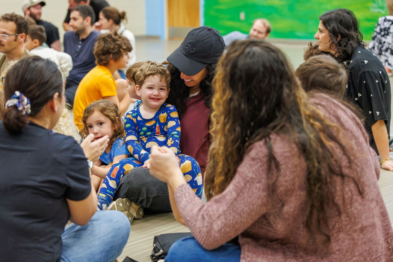 Children and adults gather in a classroom setting for an interactive learning activity or workshop.