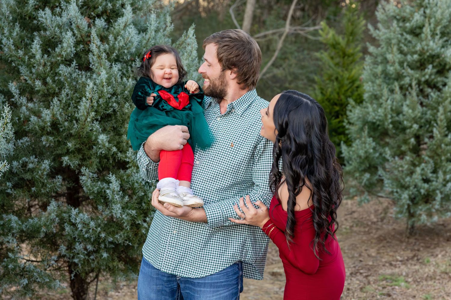 Outdoor family photo session with evergreen trees creating a natural backdrop.