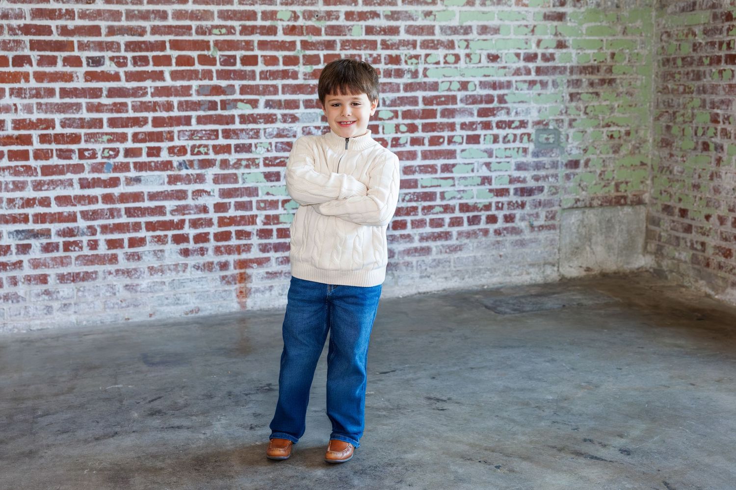 Casual group portrait against textured brick wall background.