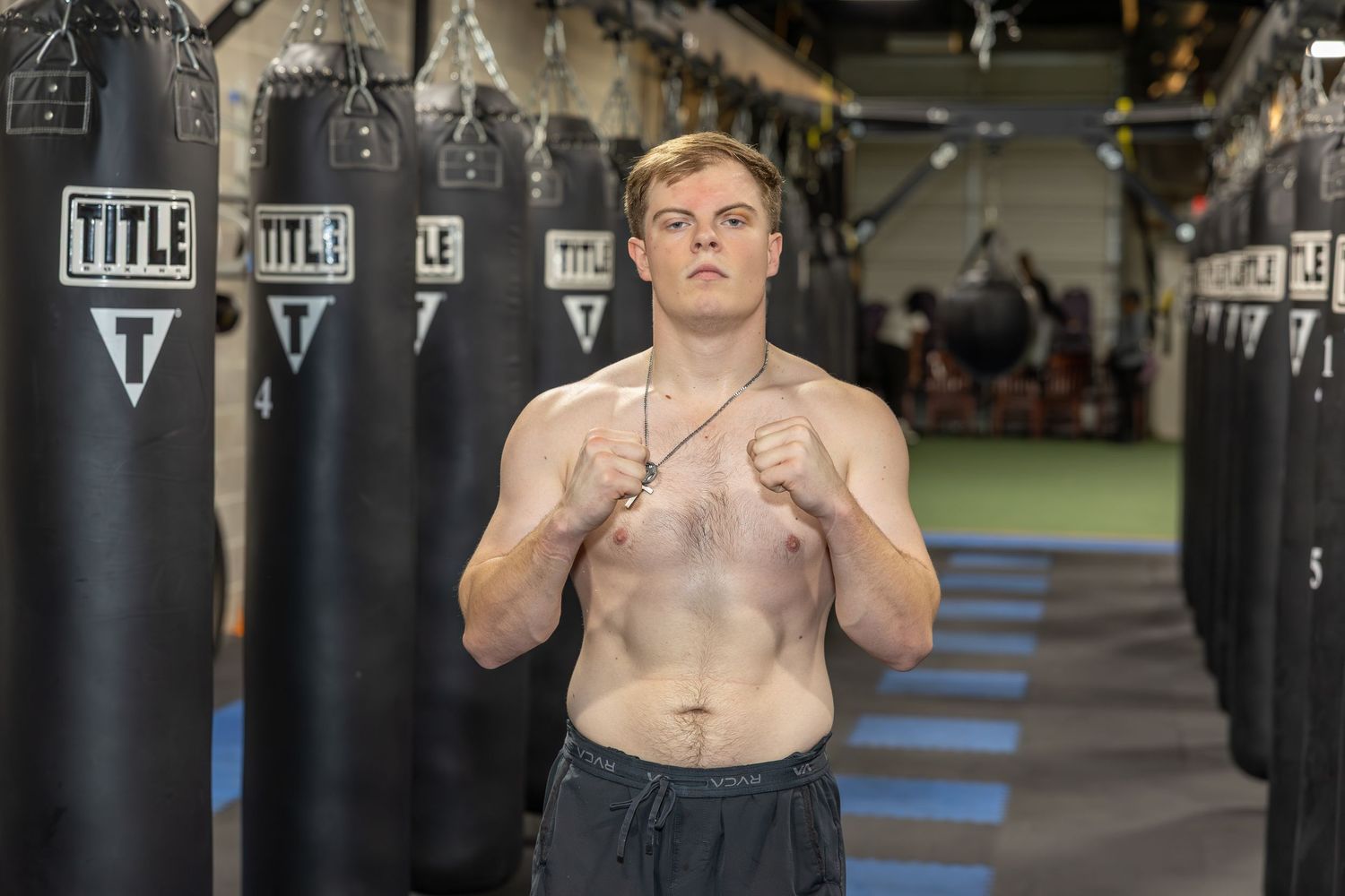 Boxing gym interior with multiple heavy bags hanging from ceiling.