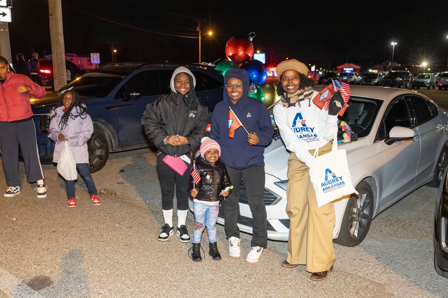 Small group gathered in a parking lot during an evening community event.
