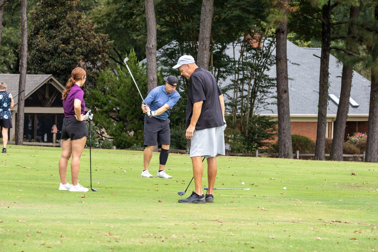 Golfers practicing their putting skills on a sunny course.