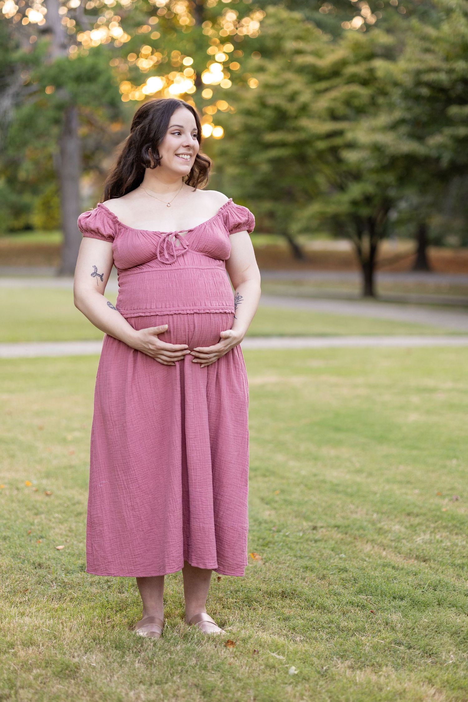Pink dress against natural garden backdrop with golden sunset lighting.