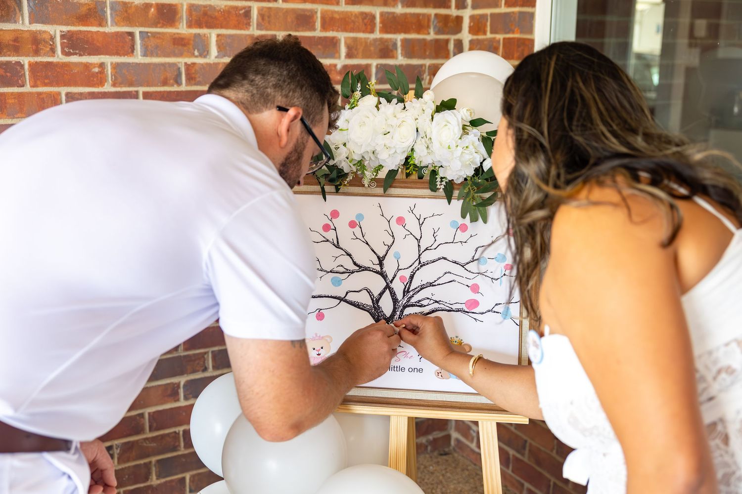 Decorative white and floral arrangements against a rustic brick wall setting.