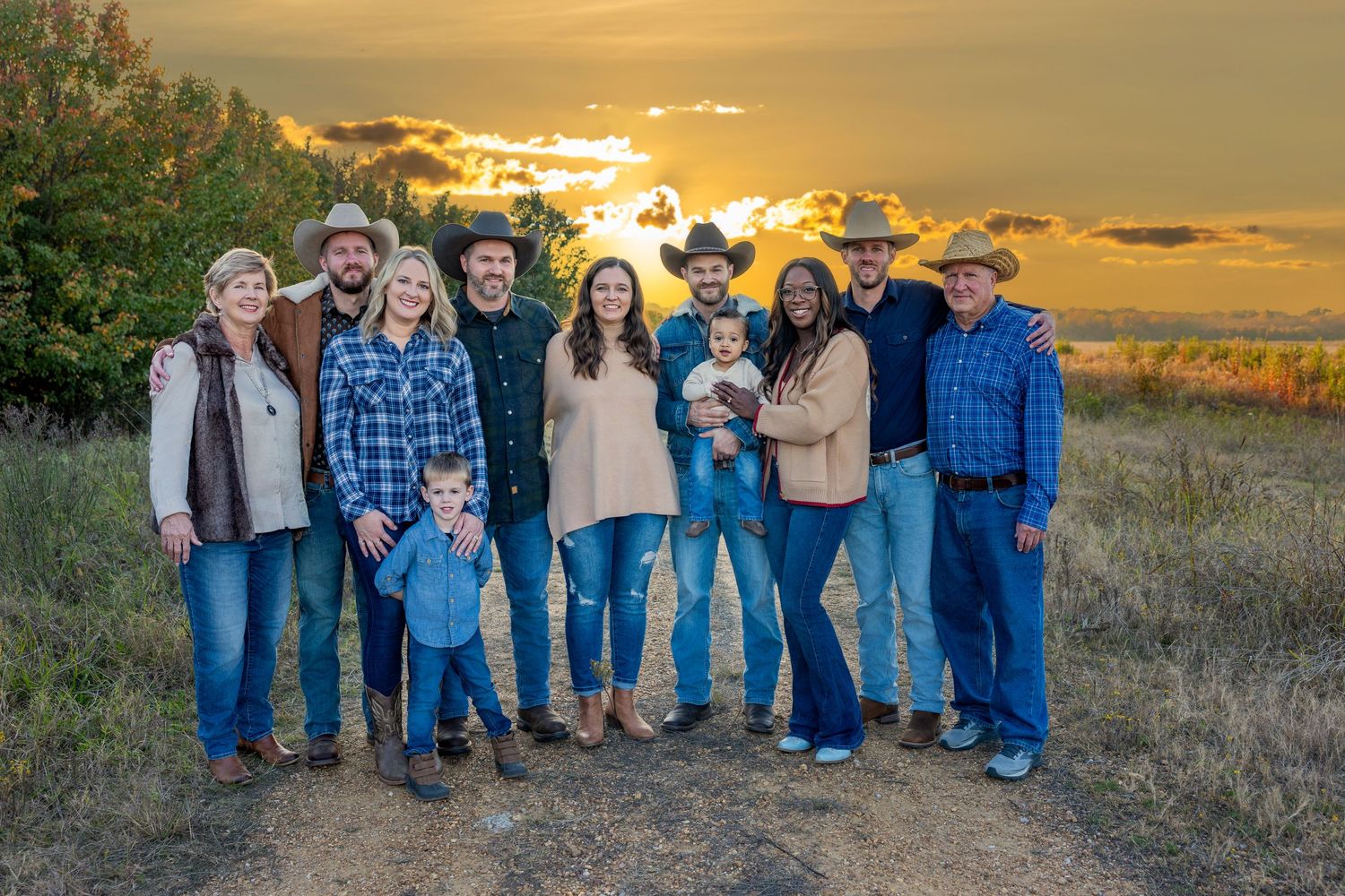Extended family portrait in matching denim against golden sunset backdrop.
