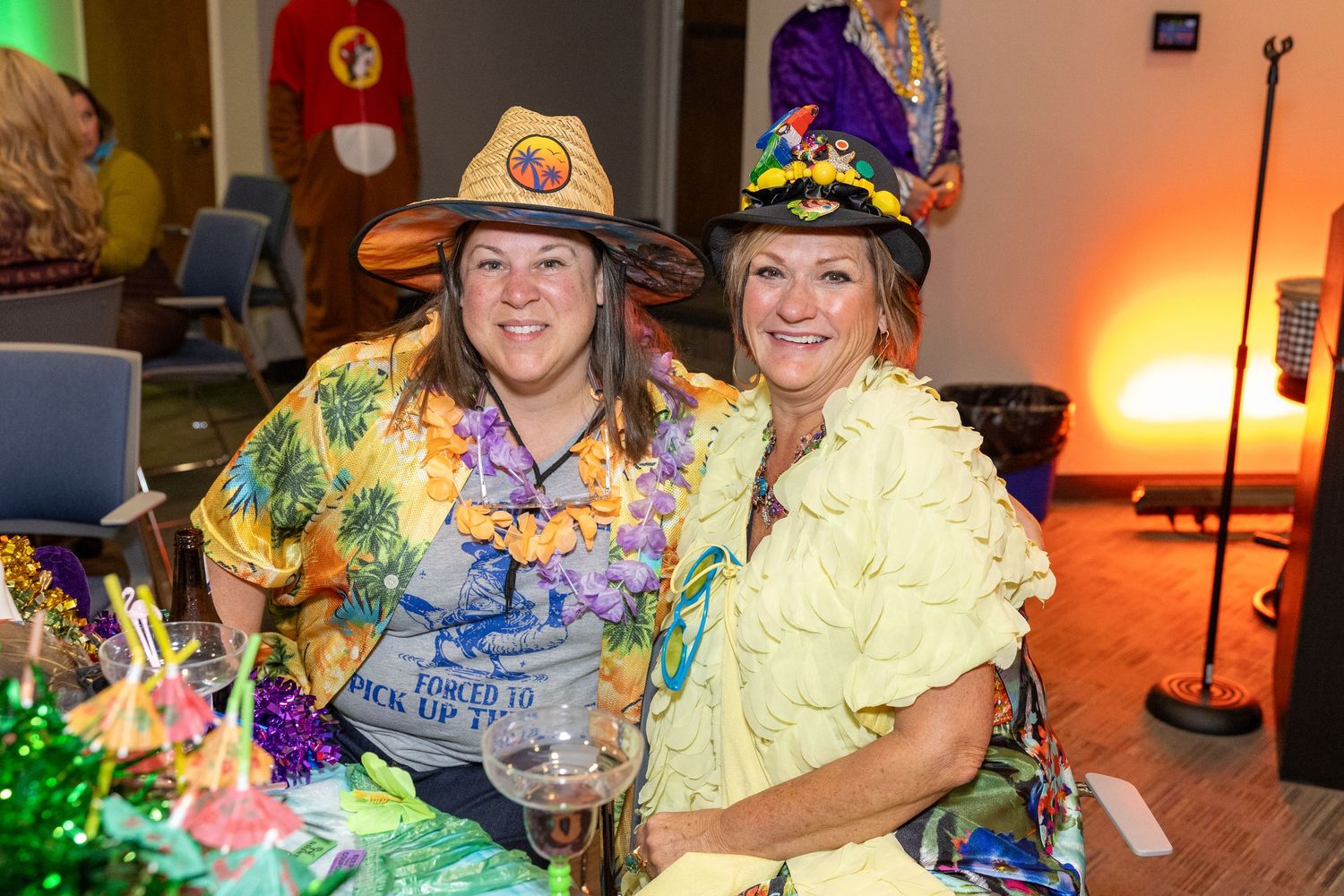 Partygoers in colorful Halloween costumes gathering at a festive indoor celebration.
