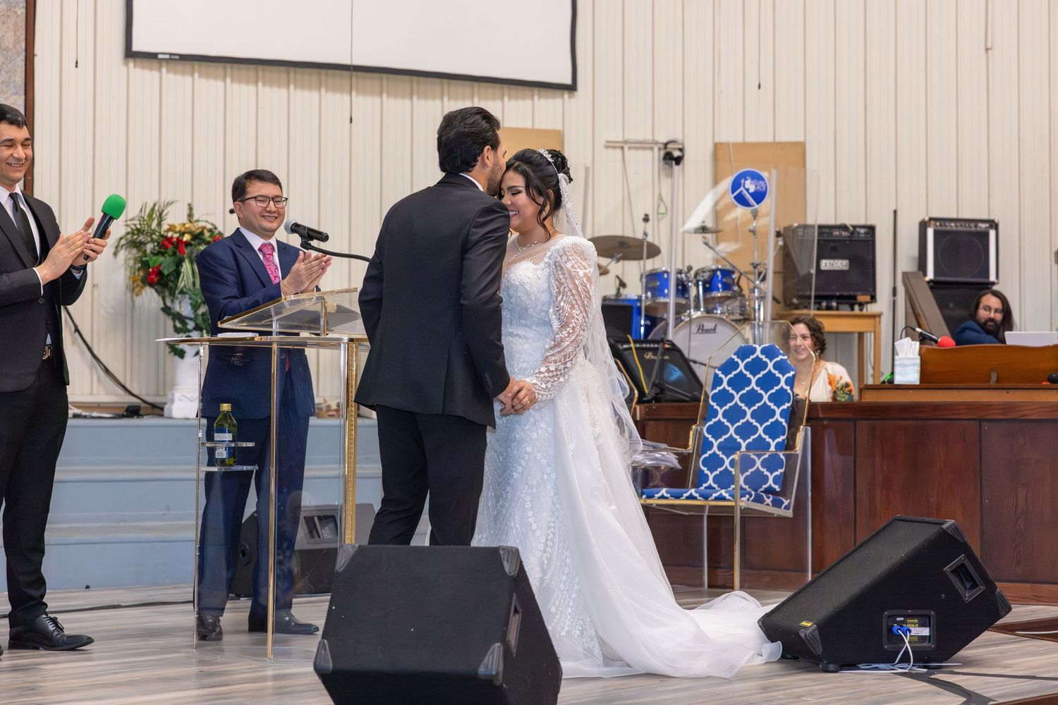 Wedding ceremony in a modern church hall with white walls and wooden details.