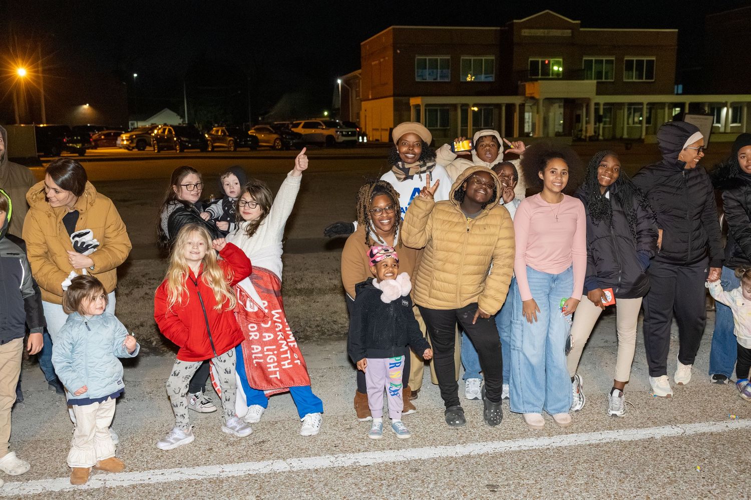 Group of attendees posing enthusiastically at a nighttime outdoor gathering.