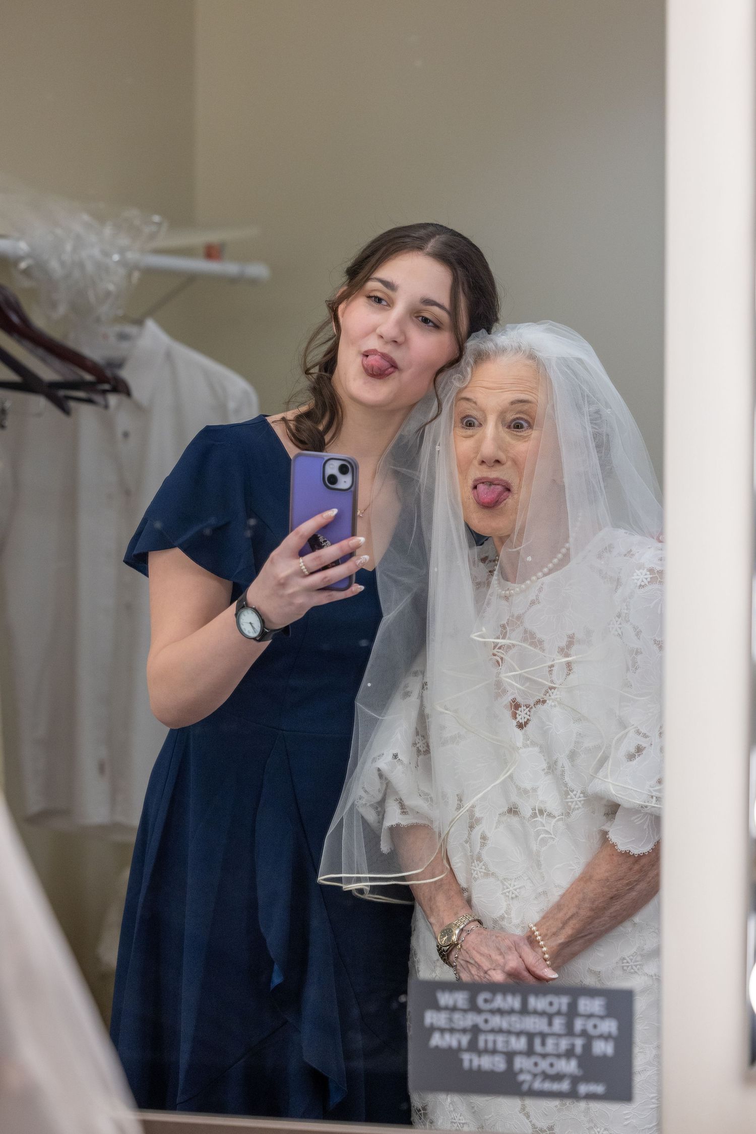 Two people share a joyful moment during a wedding ceremony while holding a framed document.