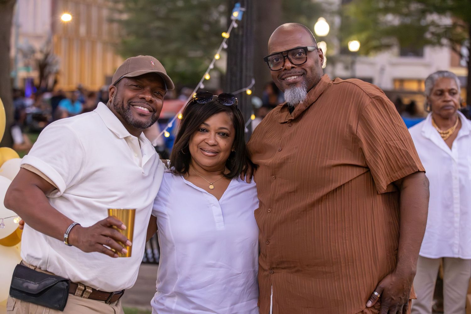 People in white shirts and casual attire gathering at an outdoor community event.