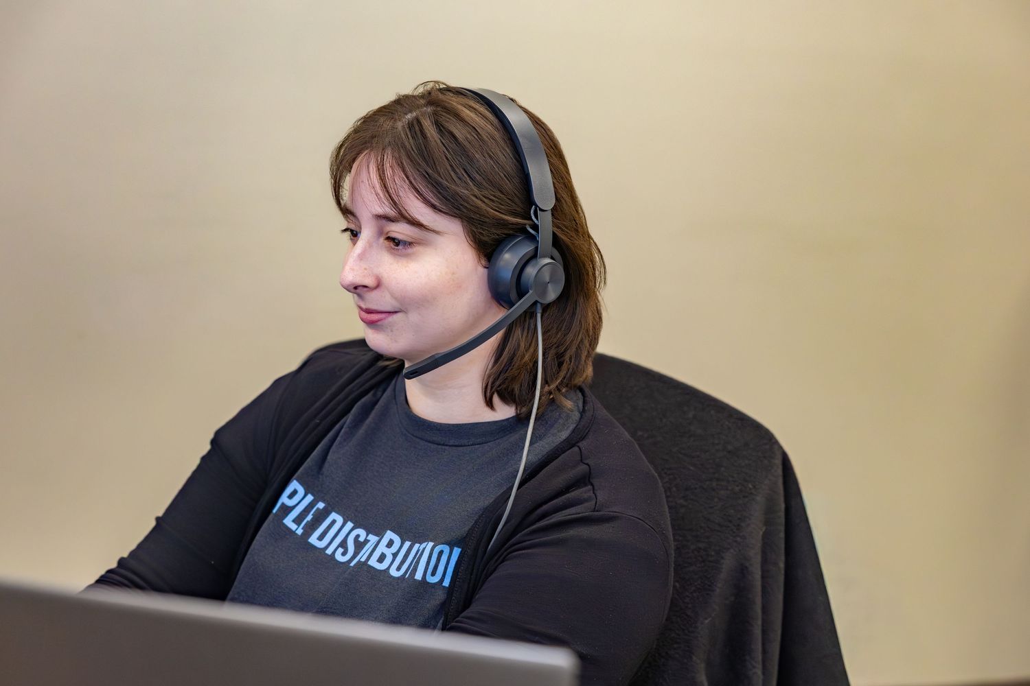 Customer service representative wearing headset while working in office environment.