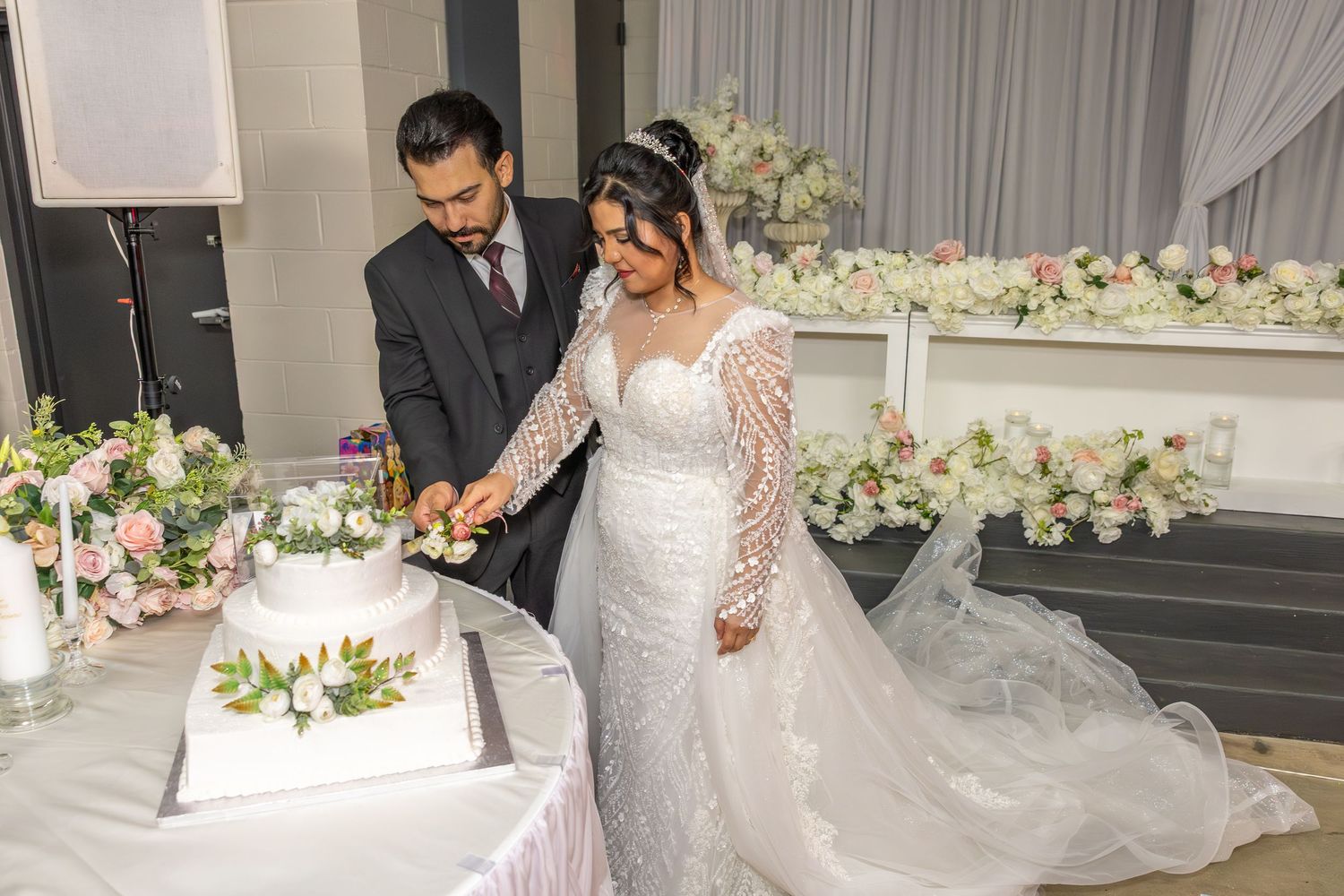 Romantic wedding venue decorated with white draping and floral arrangements for the ceremony.