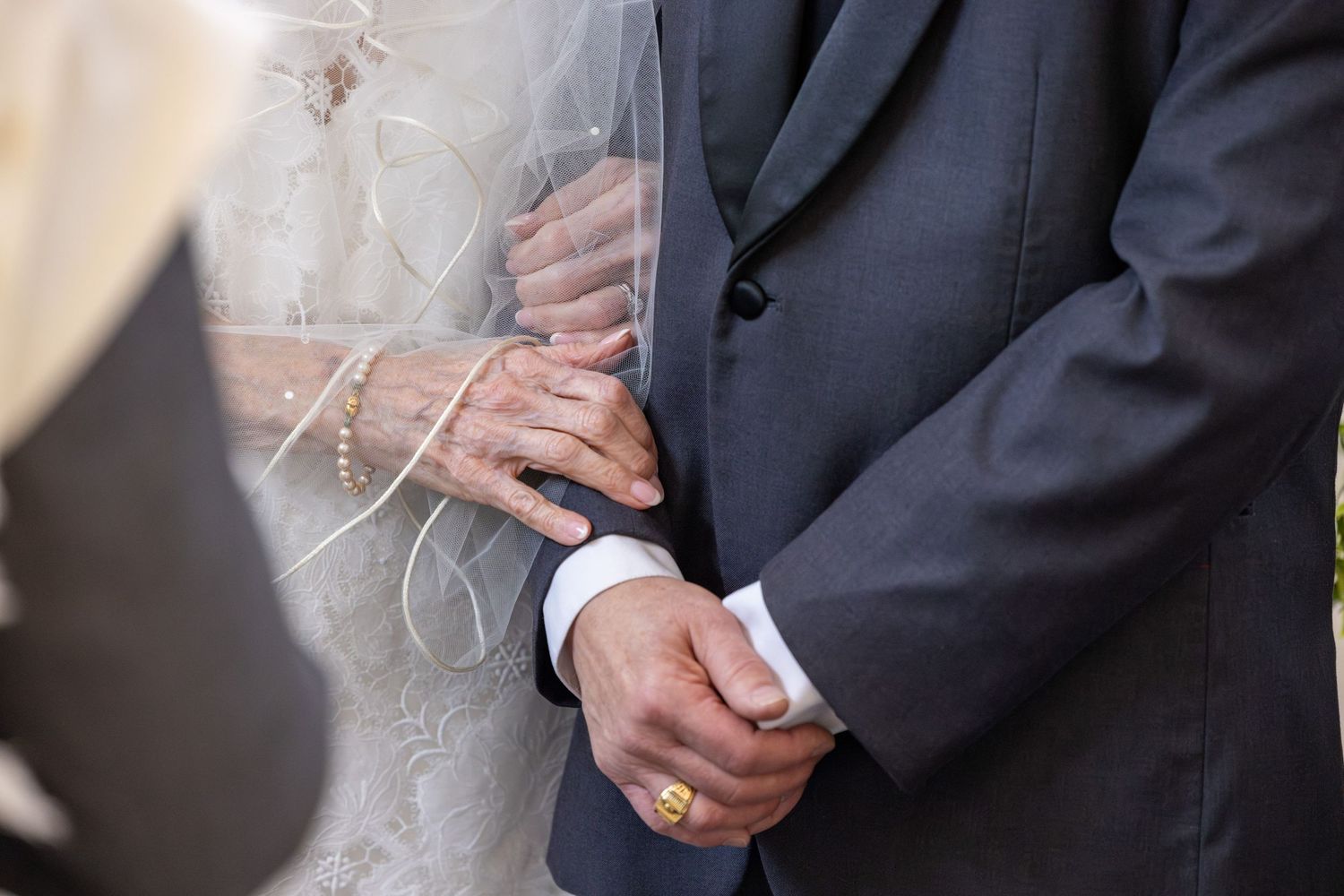 Close-up of hands in formal attire adjusting a tie and suit jacket in multiple sequential shots.