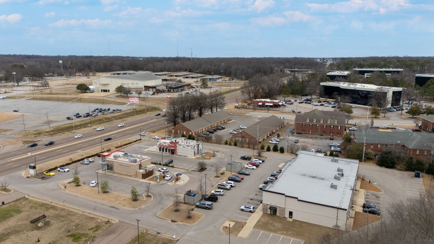 Aerial panoramic view of an industrial facility with warehouses and storage yards in a rural setting.