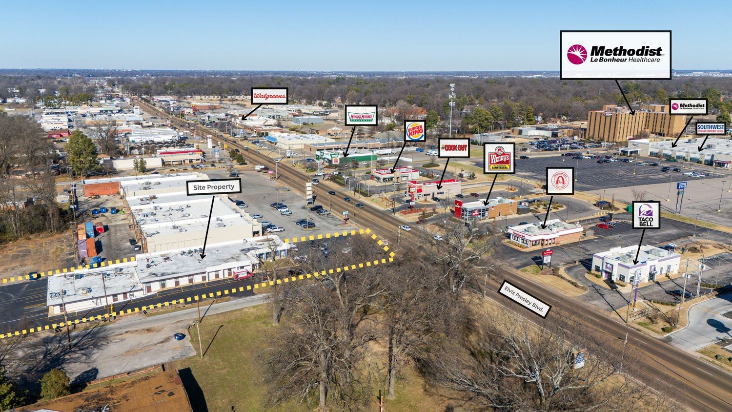 Aerial panoramic view of industrial buildings and railroad tracks with snow-covered landscape in winter.